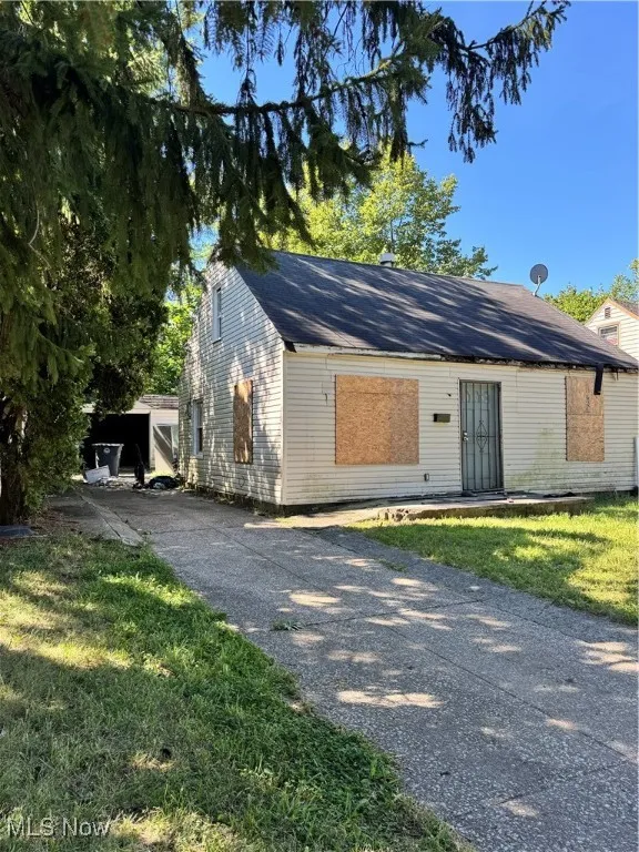 View of front facade with a front yard and a shingled roof