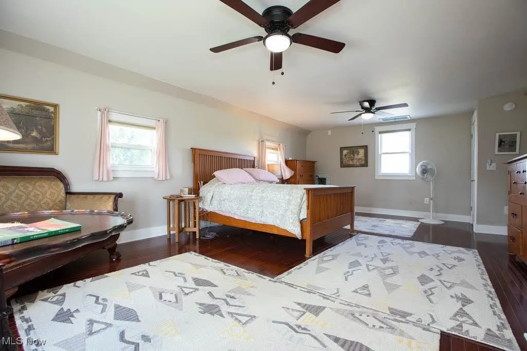 Bedroom with a ceiling fan and dark wood finished floors