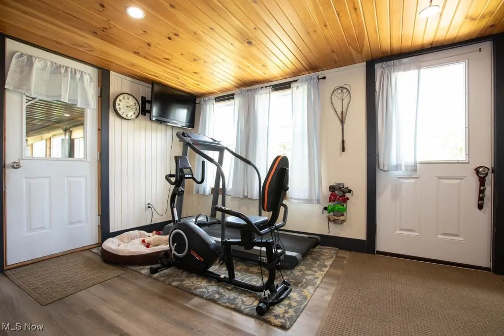 Exercise area with healthy amount of natural light, wood finished floors, and wood ceiling
