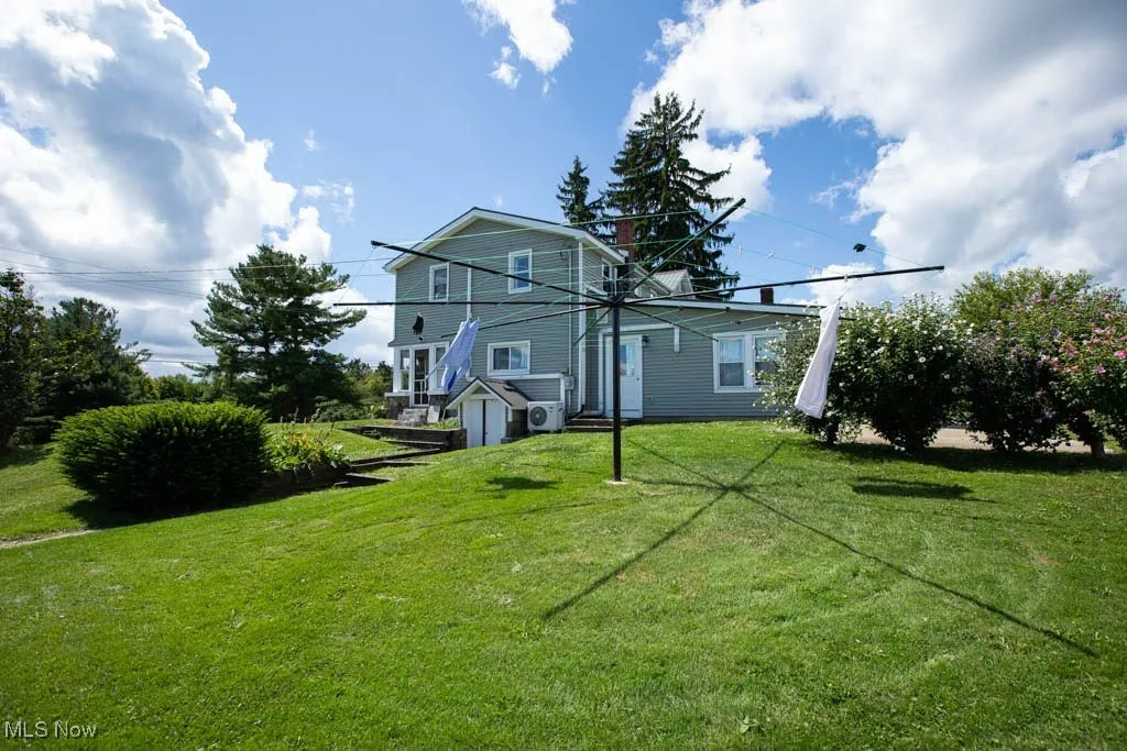 Back of property with a lawn