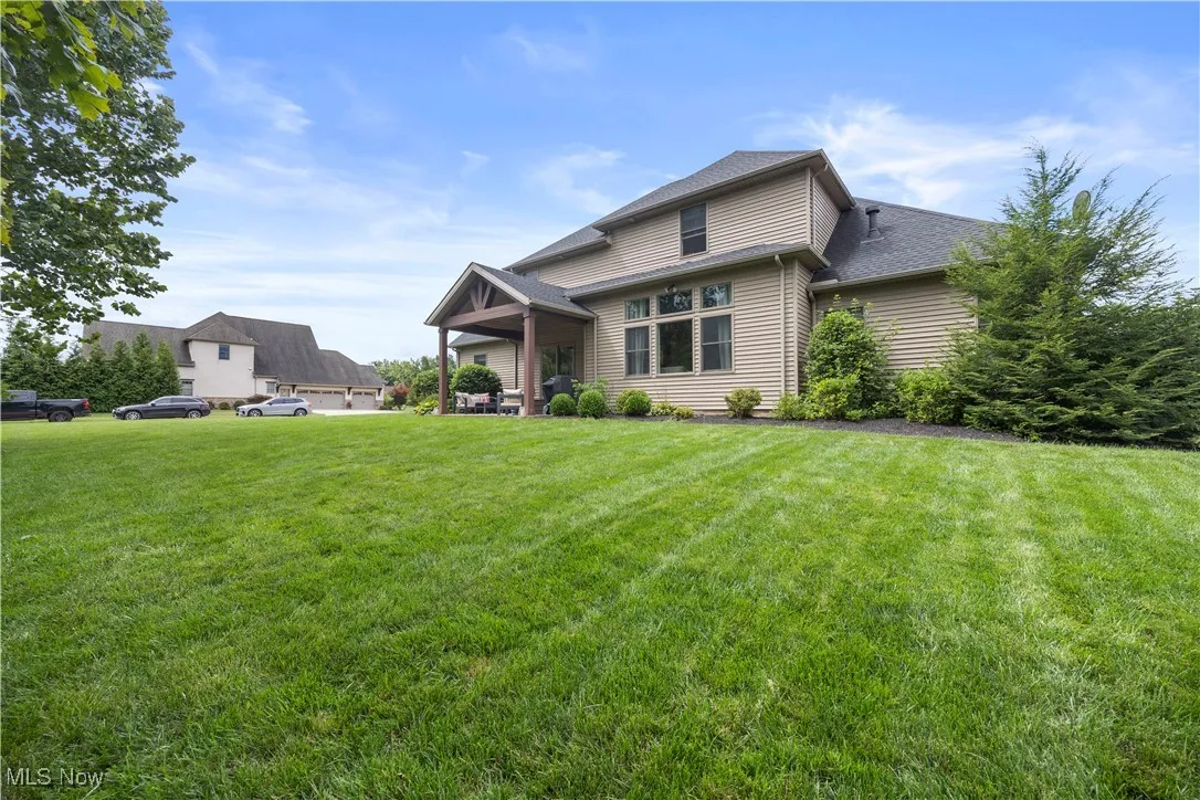View of front of house featuring a patio, a front yard, and a shingled roof