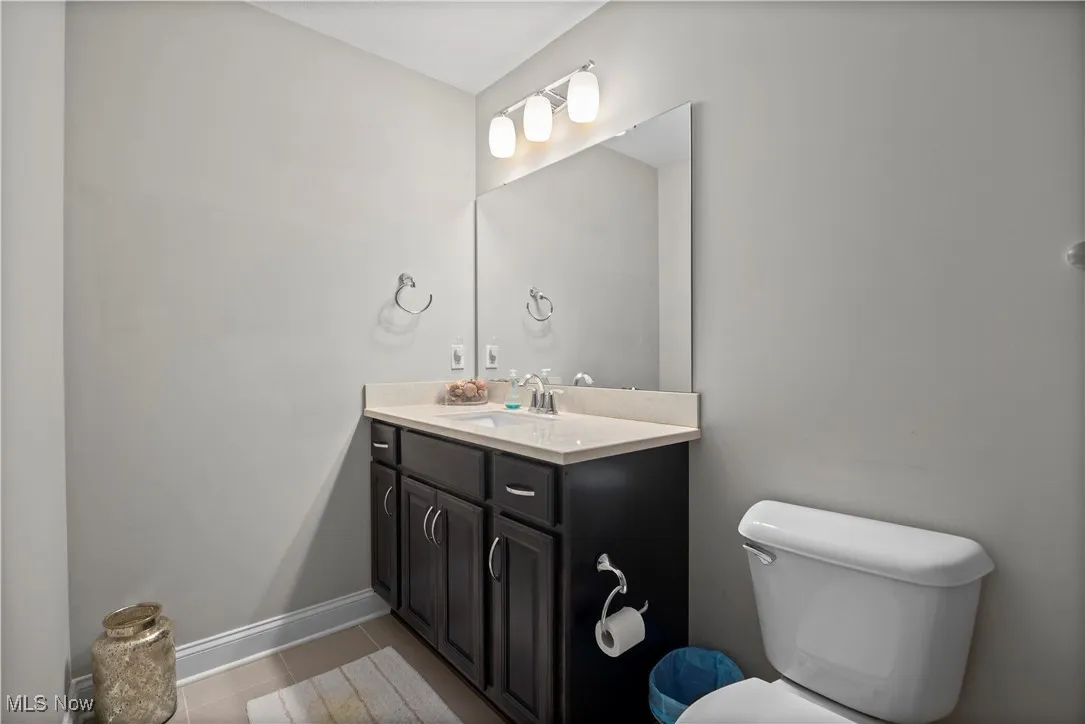 Half bath with vanity and light tile patterned floors