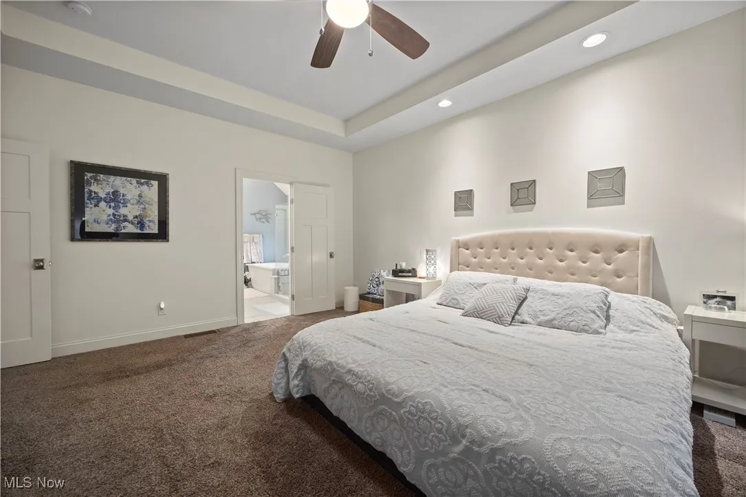 Bedroom with dark colored carpet, recessed lighting, and a ceiling fan
