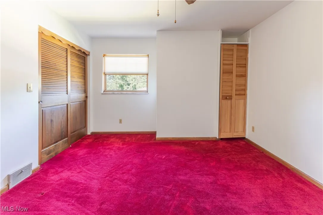 Unfurnished bedroom with a closet, carpet, and a ceiling fan