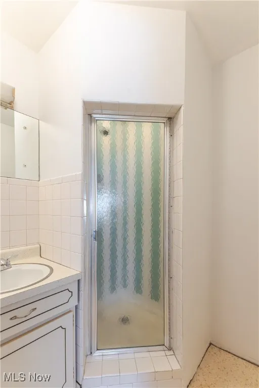 Bathroom featuring vanity and a shower stall