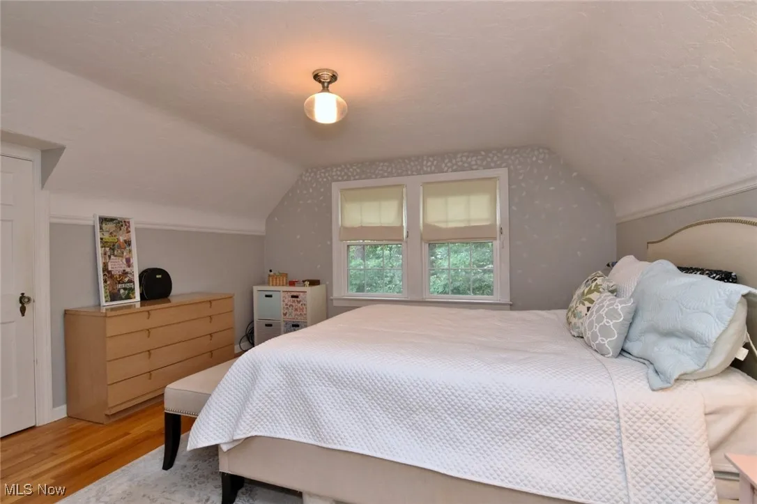 2nd floor Bedroom featuring wood finished floors, vaulted ceiling, and a textured ceiling