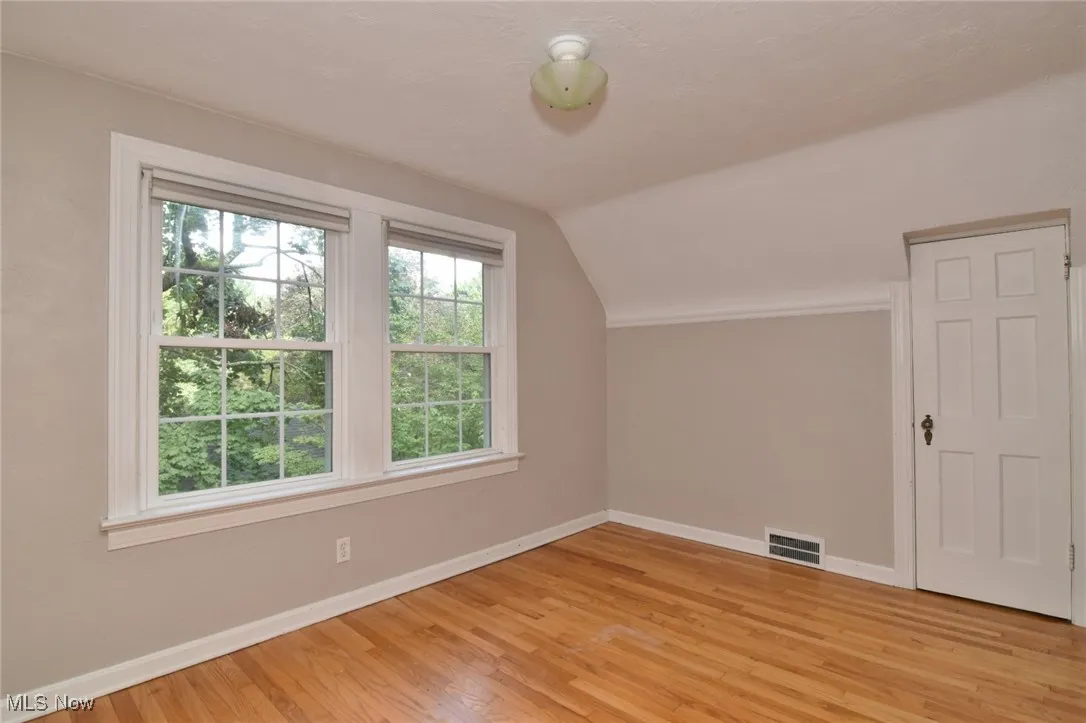 2nd floor bedroom with vaulted ceiling and light wood finished floors