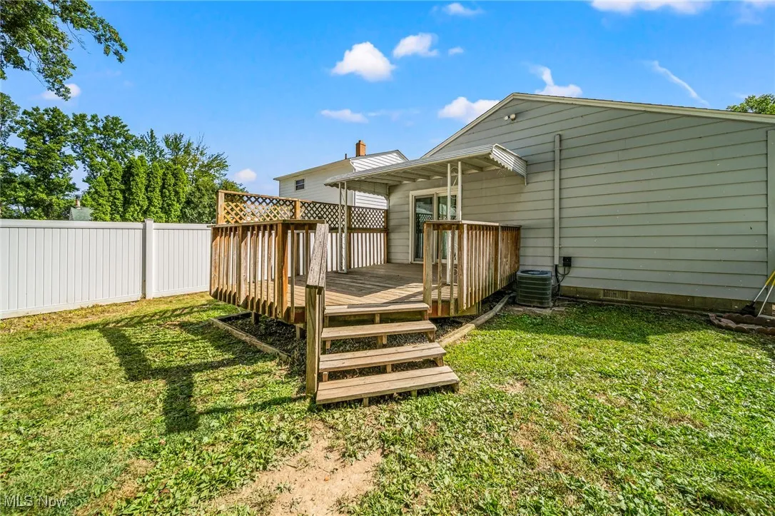 Rear view of property with a deck and a yard