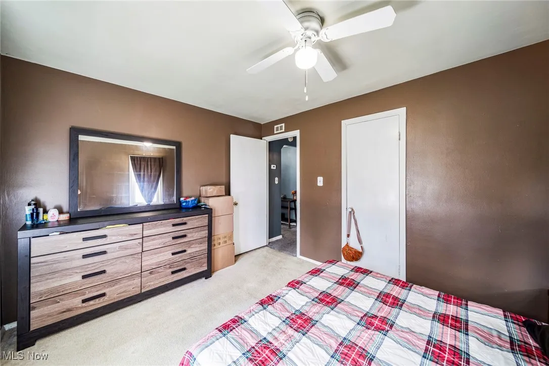 Bedroom with light colored carpet and ceiling fan