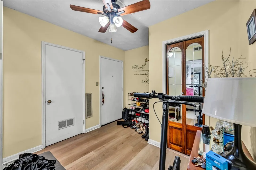 Workout area featuring light wood-type flooring and a ceiling fan