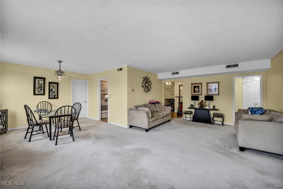 Living room with carpet and a ceiling fan