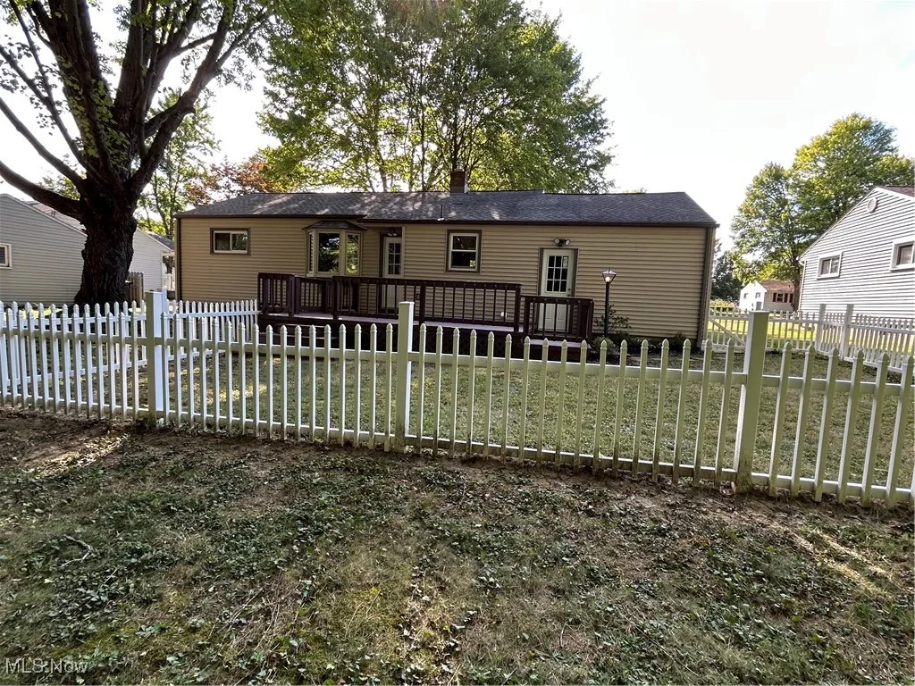 Rear view of house with a fenced backyard and a deck