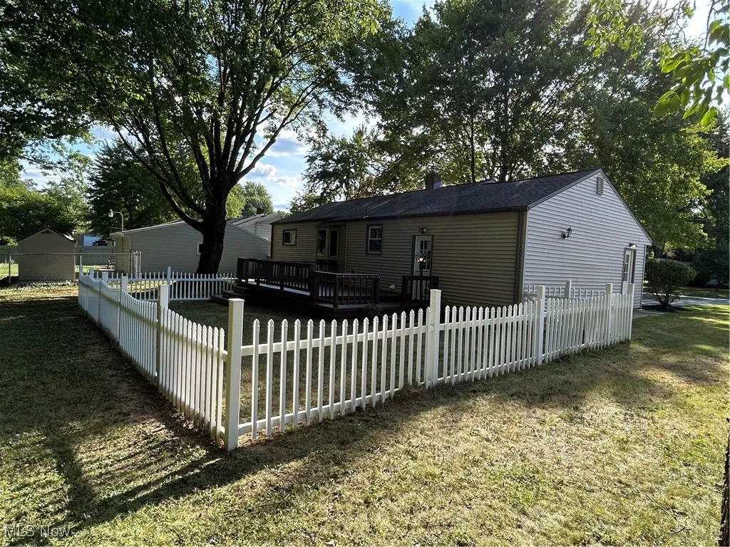 Back of house with a wooden deck and a chimney