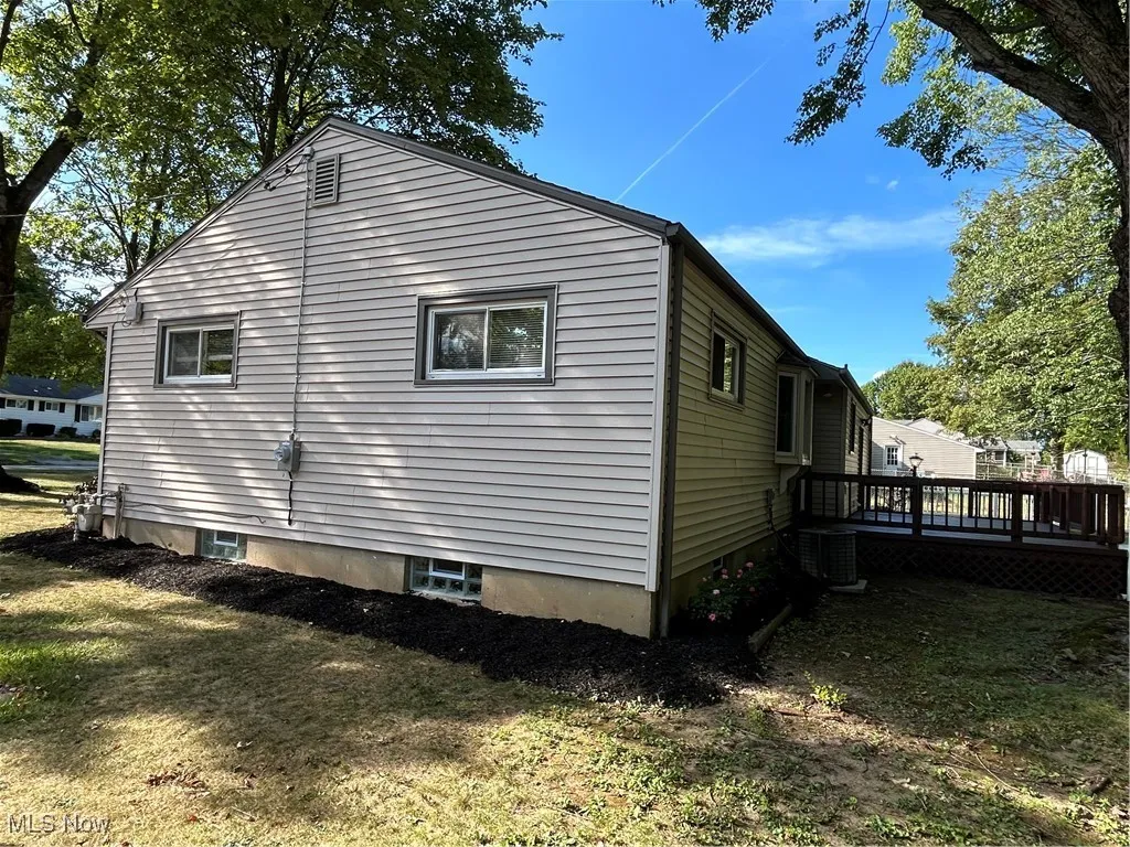 View of side of home featuring a deck and a yard