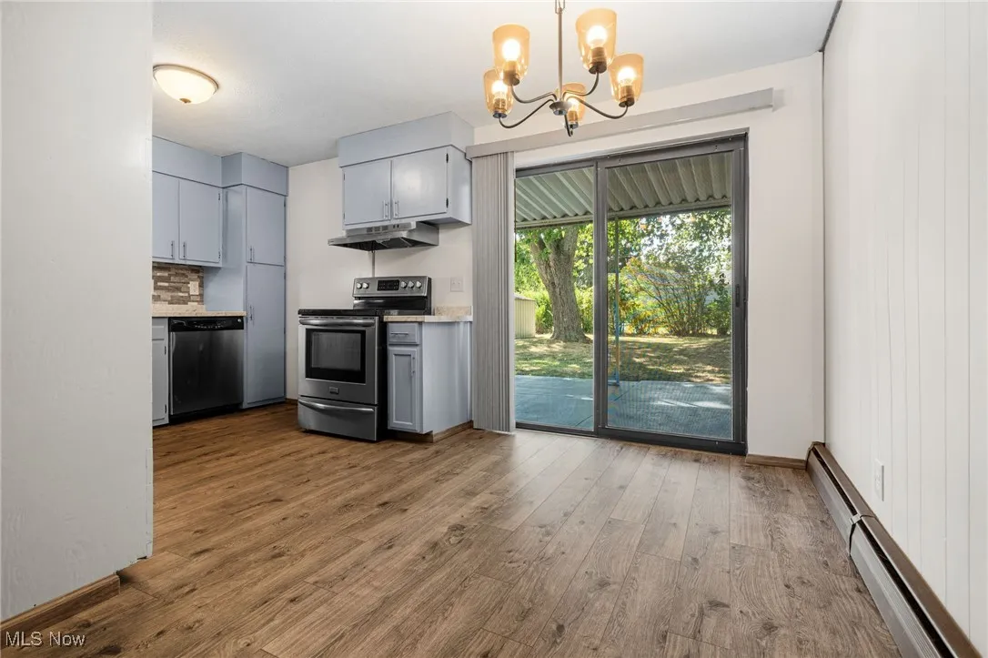 Lovely remodeled eat in kitchen with stainless steel appliances, LVT flooring and sliding door out to the patio