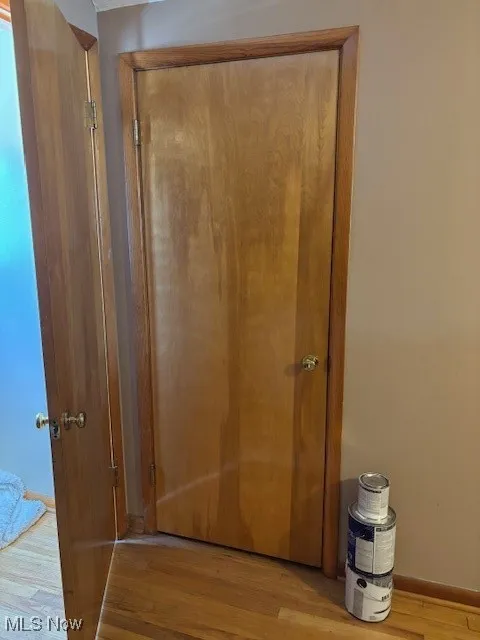 Corridor with wood finished floors and baseboards