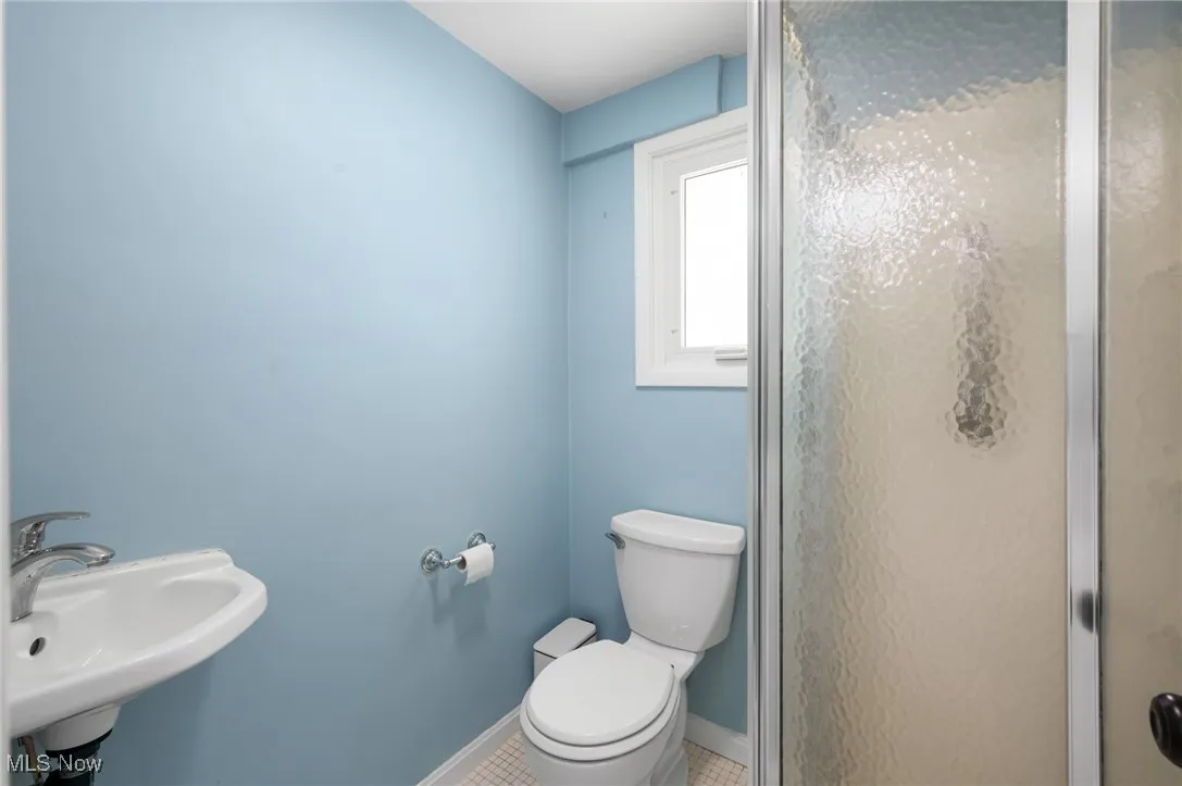 Full bathroom featuring a shower stall and tile patterned floors