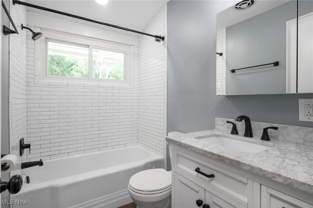 Full bath featuring  shower combination and vanity