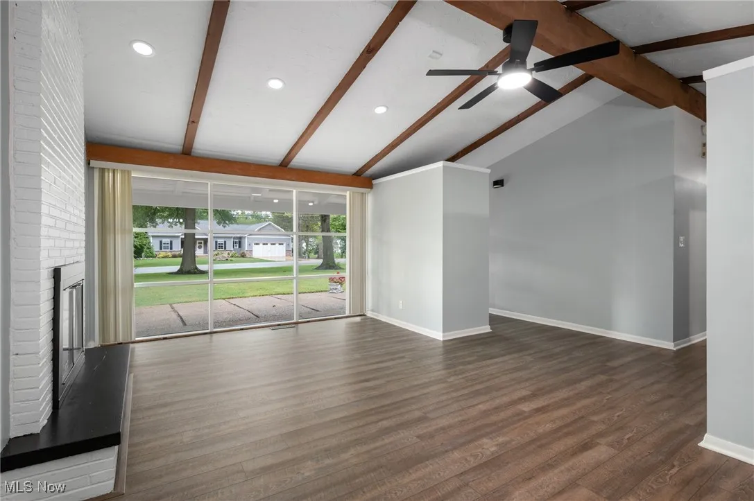 Unfurnished living room with dark wood-type flooring, a brick fireplace, recessed lighting, and ceiling fan