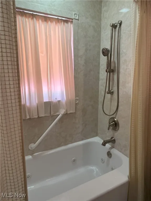 Bathroom featuring a combined bath / shower with jetted tub