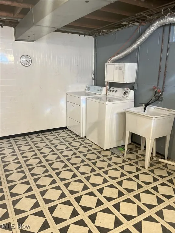 Laundry area featuring washing machine and dryer and light floors