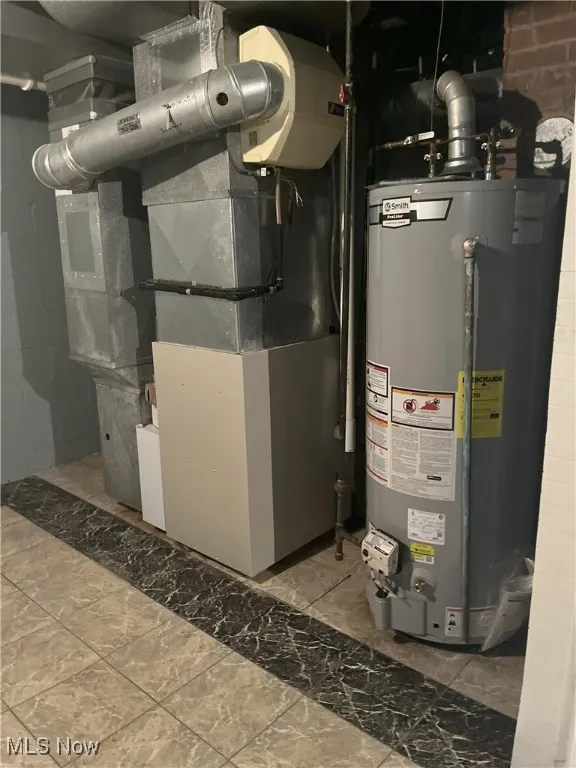 Utility room featuring water heater and heating unit