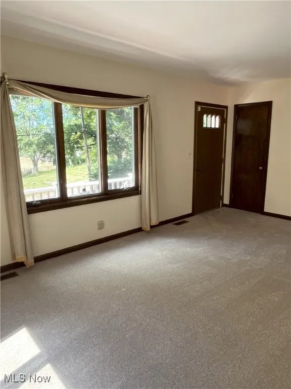 Carpeted empty room with baseboards