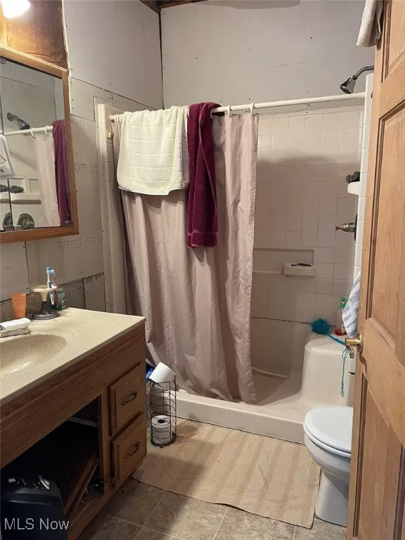 Bathroom featuring a shower stall, vanity, and tile patterned flooring
