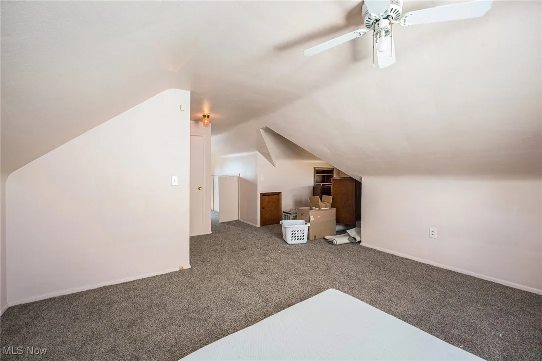 Additional living space with carpet and lofted ceiling
