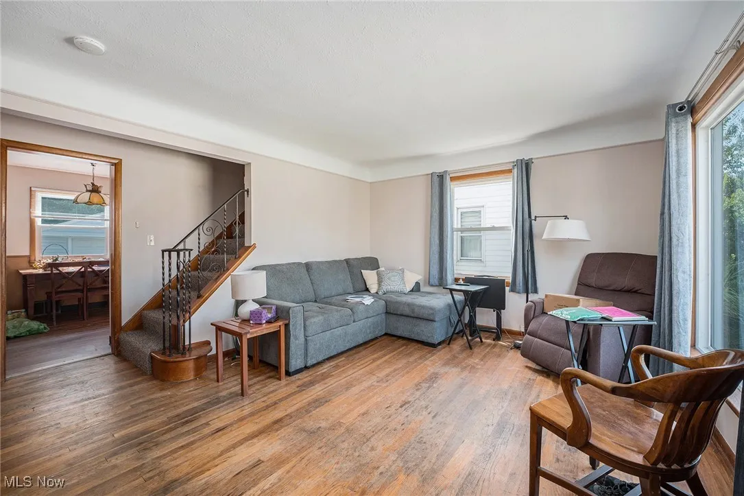 Living area with stairway, wood finished floors, and plenty of natural light