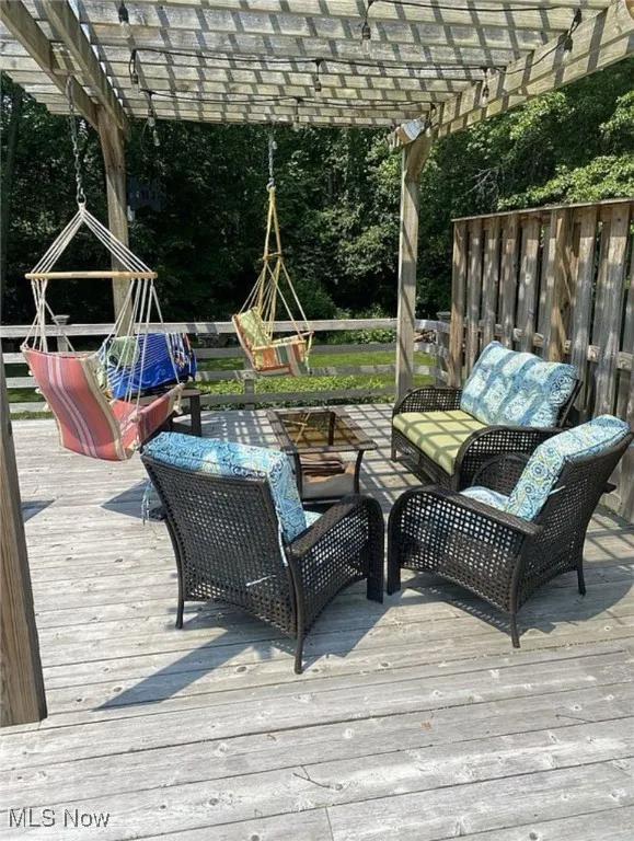 Wooden terrace featuring an outdoor living space and a pergola