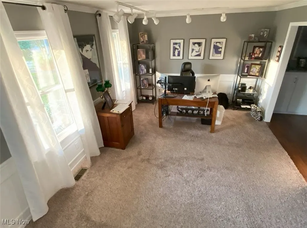 Office space featuring track lighting and light colored carpet