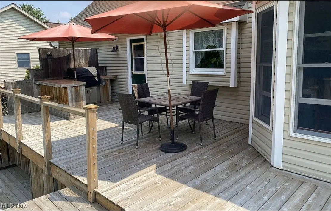 Deck with outdoor dining space and a grill