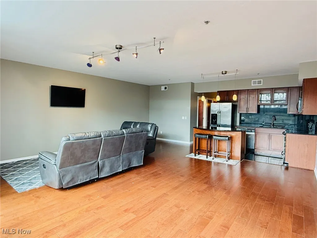 Living area featuring light wood-style floors and rail lighting