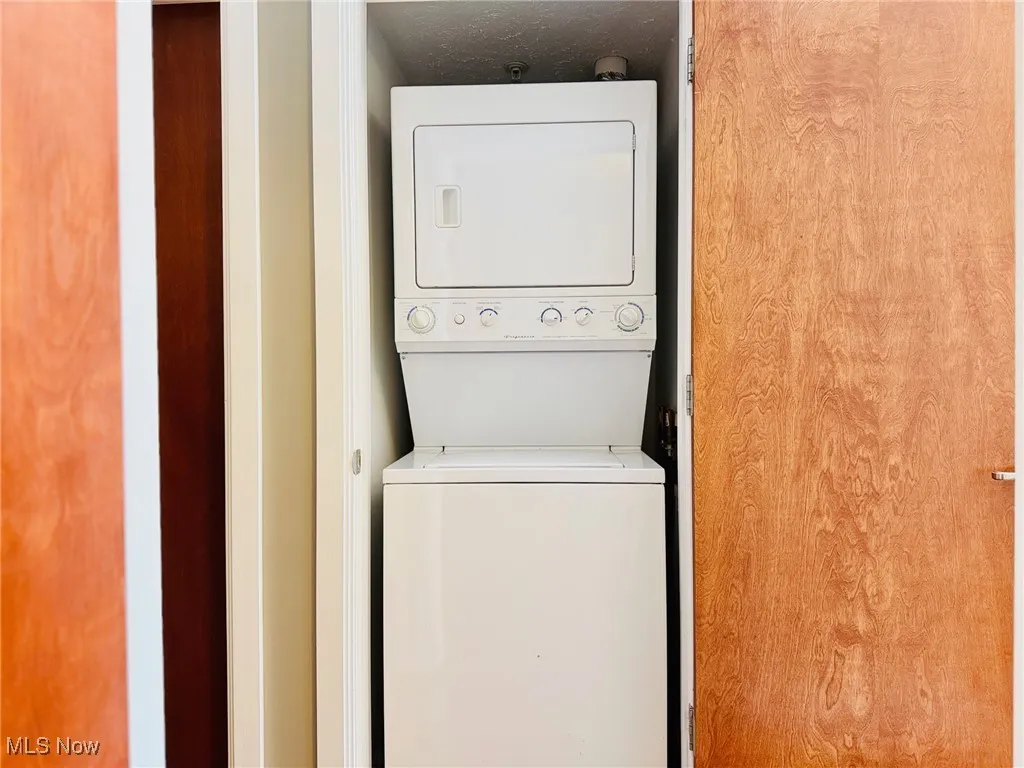 Washroom featuring stacked washer and clothes dryer