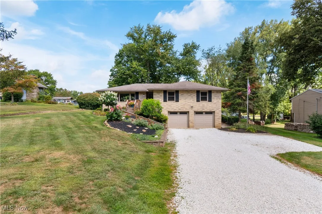 Single story home with a front yard, driveway, a garage, and brick siding