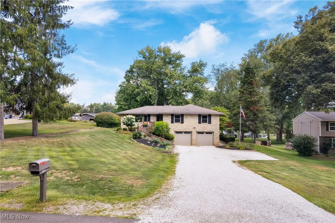 View of front of home with driveway, a front lawn, and an attached garage