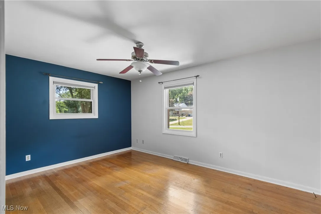 Spare room with light wood finished floors and ceiling fan