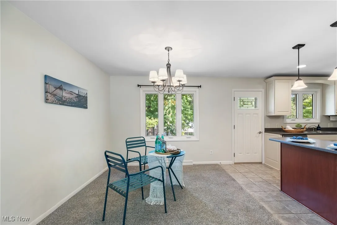 Dining area featuring plenty of natural light, light tile patterned floors, and light colored carpet