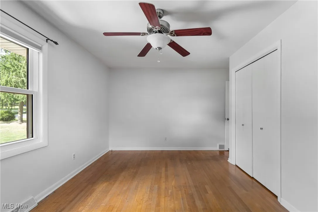 Unfurnished bedroom featuring wood-type flooring, a closet, and ceiling fan