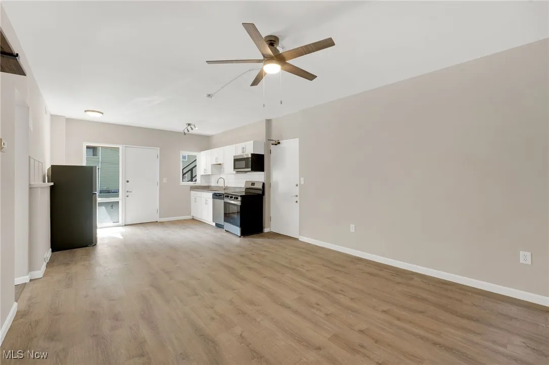Unfurnished living room with light wood-style floors and a ceiling fan