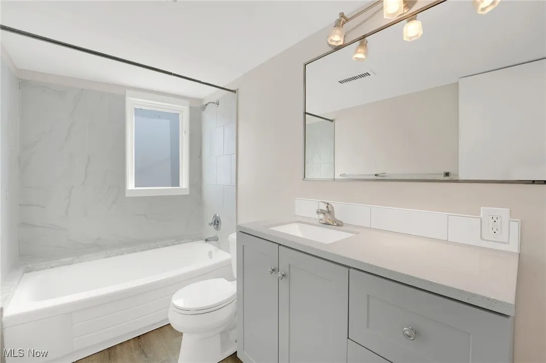 Full bathroom featuring bathtub / shower combination, vanity, and light wood-type flooring