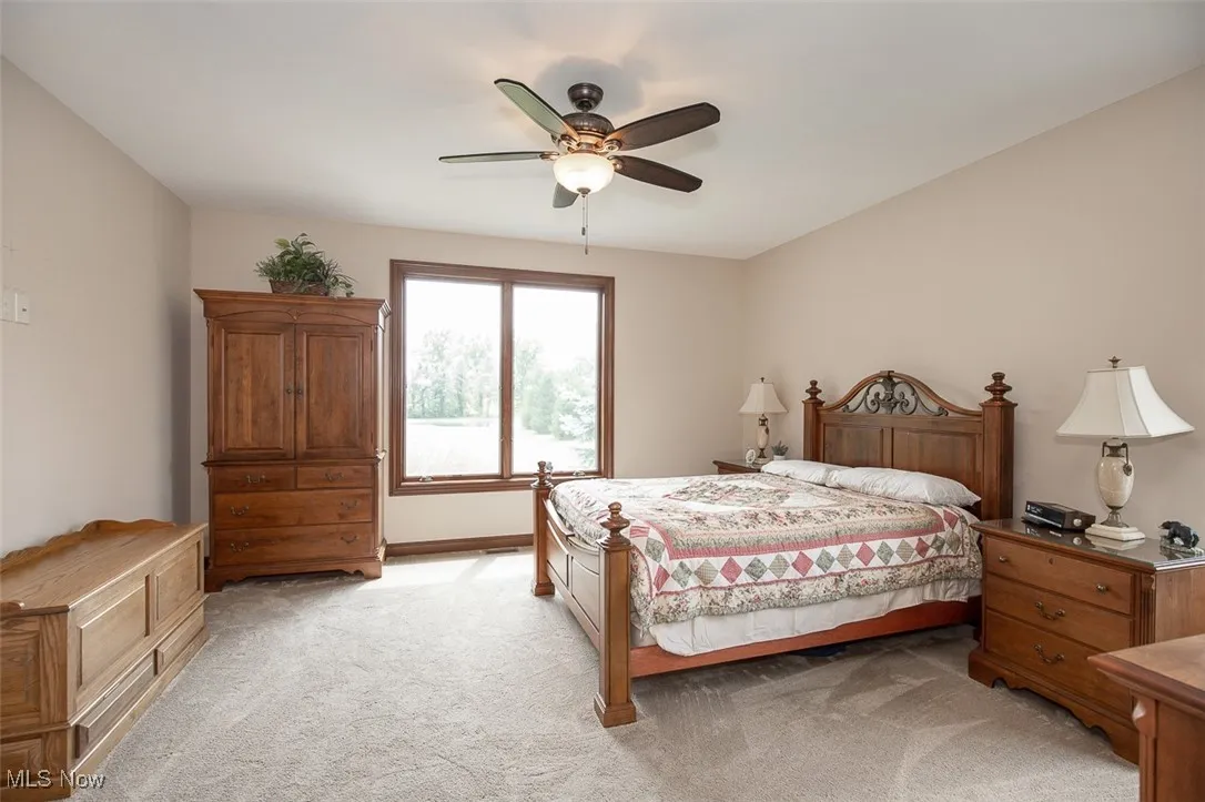 Bedroom featuring light colored carpet and a ceiling fan