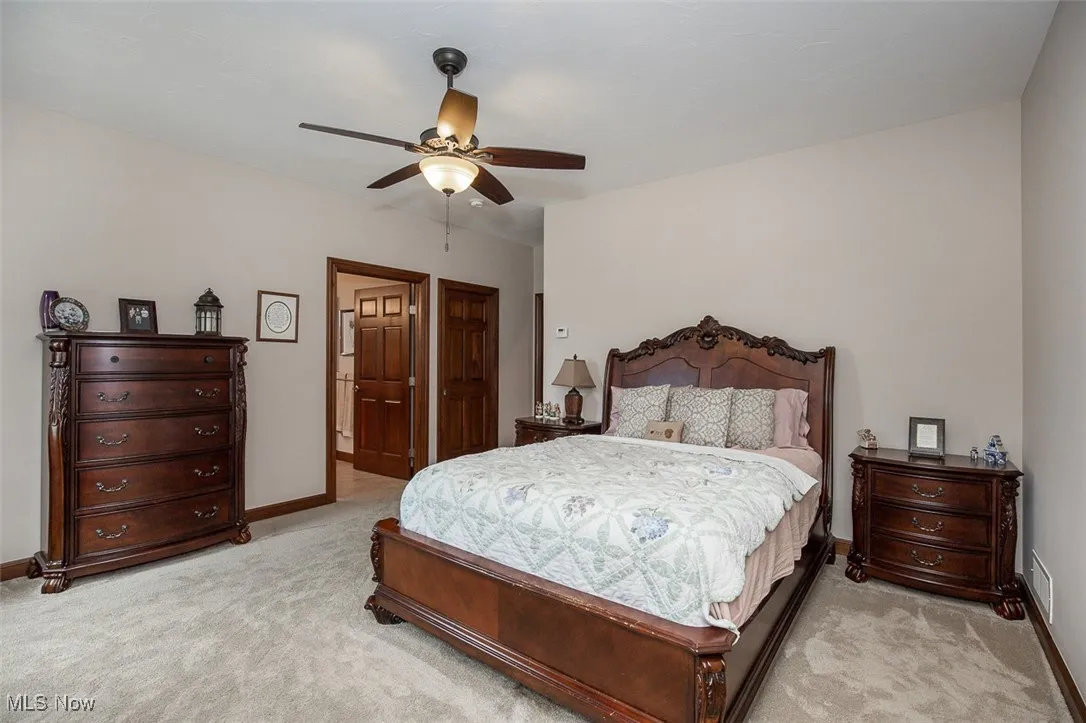 Bedroom with light carpet and a ceiling fan