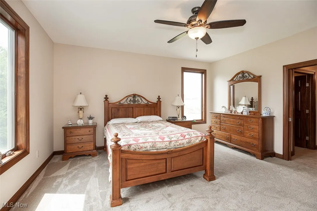 Bedroom with light carpet and ceiling fan