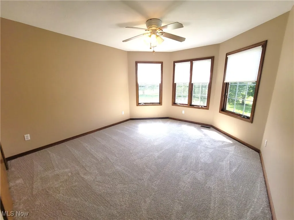 Spare room featuring carpet floors and a ceiling fan