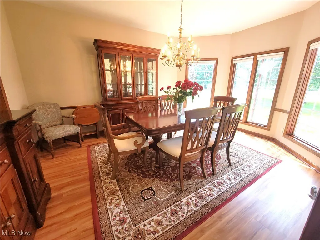 Dining space with light wood finished floors and a chandelier
