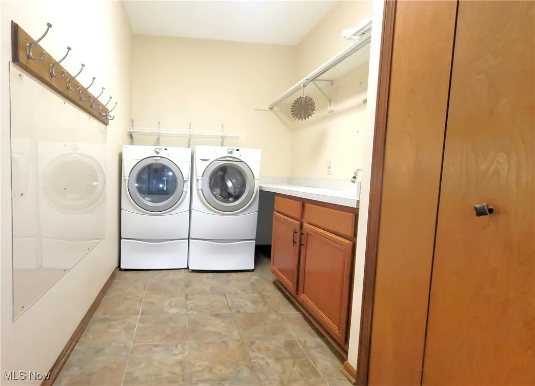 Laundry room with separate washer and dryer and cabinet space