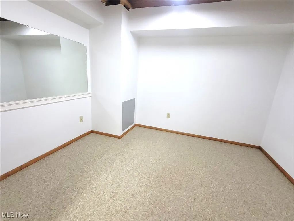 Carpeted empty room featuring baseboards