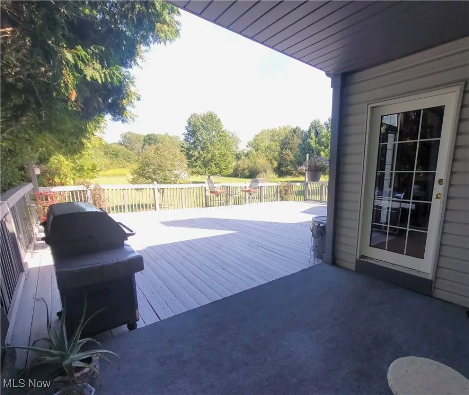 Wooden deck with grilling area and view of wooded area